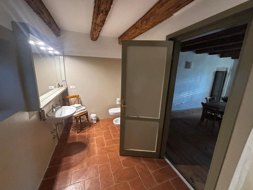 een badkamer met een toilet, een wastafel en een deur bij La Vineria di San Mattia in Verona +89 foto's