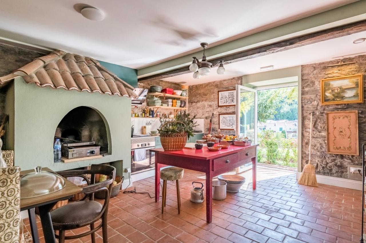 een keuken met een rode tafel en een open haard bij Villa Camélia Boutique House in Camacha