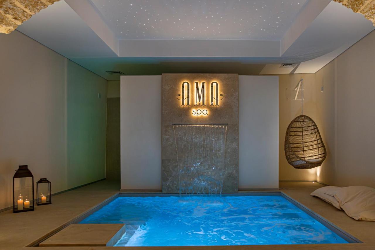 een groot blauw zwembad in een kamer met een bord bij Costamante Suites & Spa in Castellammare del Golfo