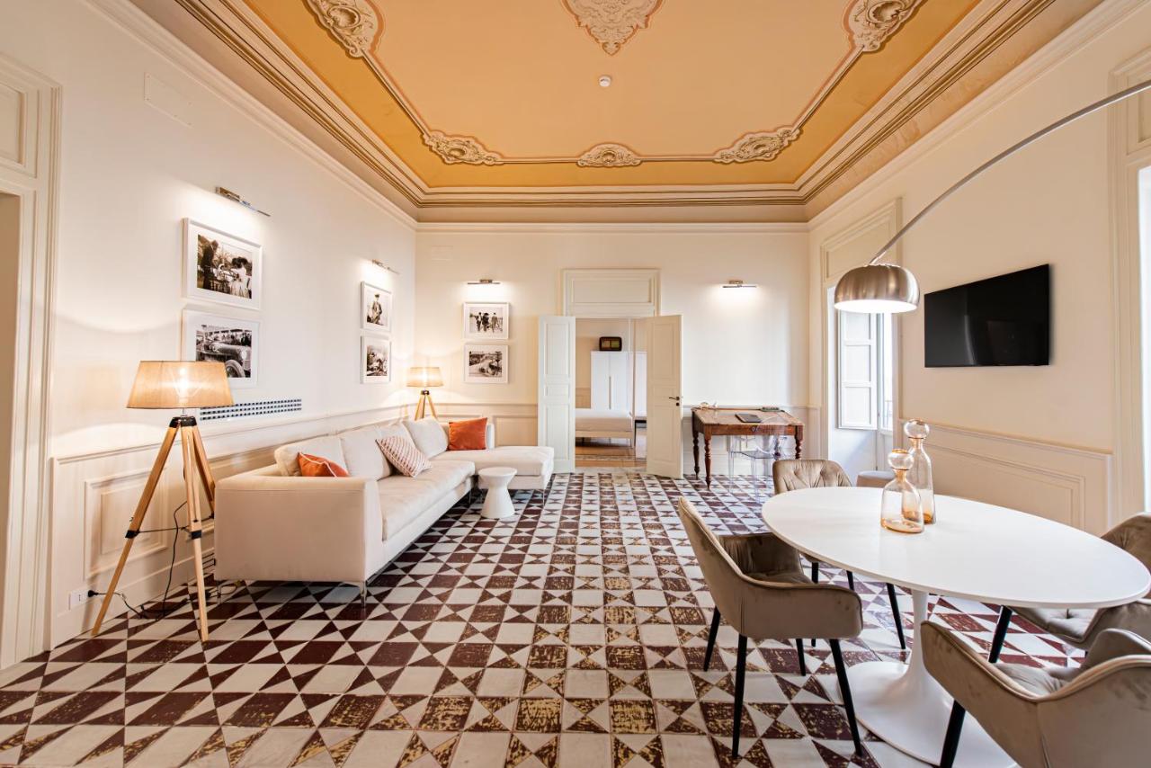 een woonkamer met een bank en een tafel bij Costamante Suites & Spa in Castellammare del Golfo