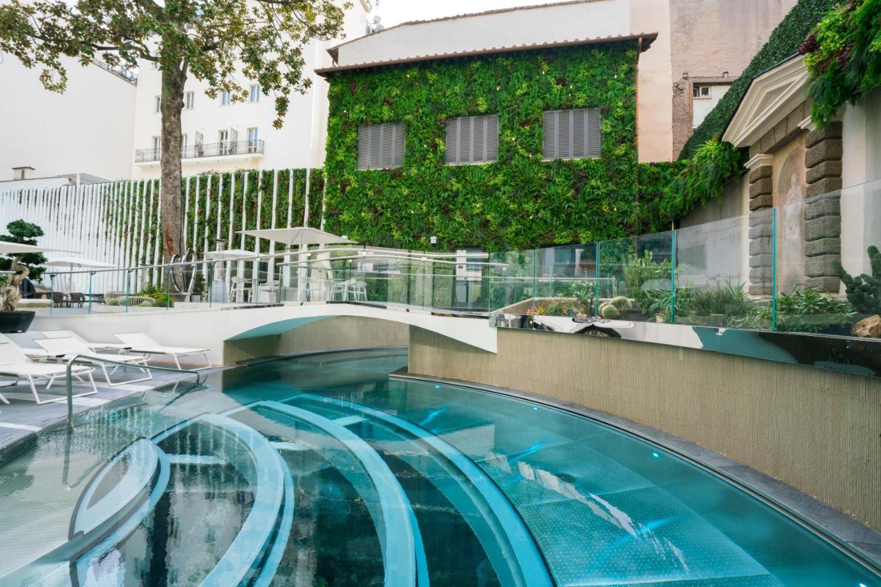 een zwembad op een gebouw met planten erop bij ROMEO Roma in Rome