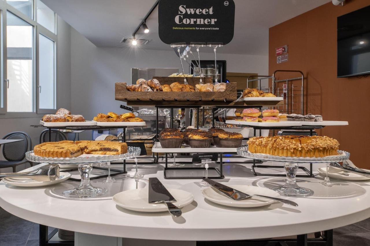 een tafel vol met allerlei soorten gebak en taarten bij B&B HOTEL Sassari in Sassari