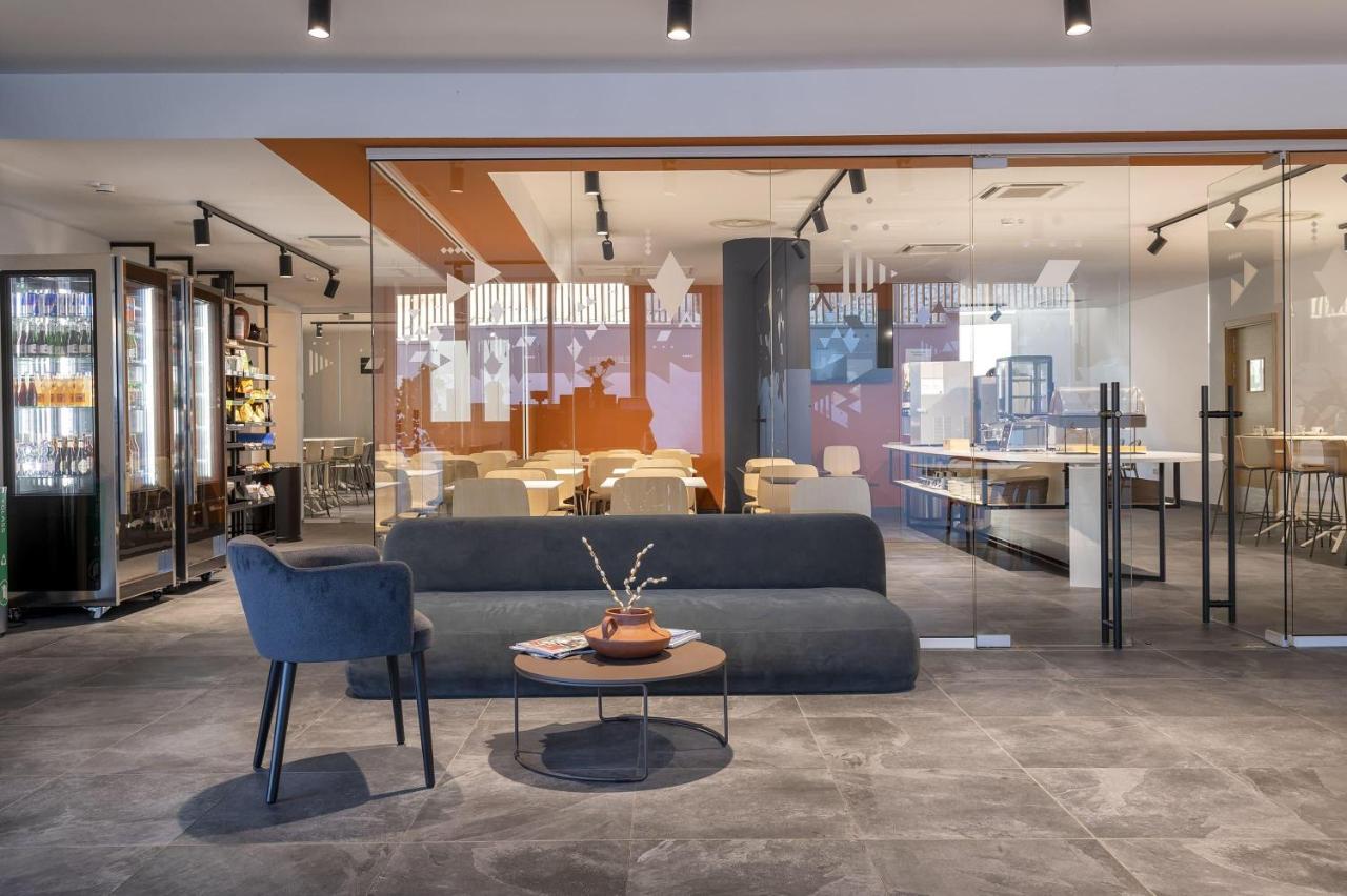 een woonkamer met een bank, een tafel en stoelen bij B&B HOTEL Sassari in Sassari
