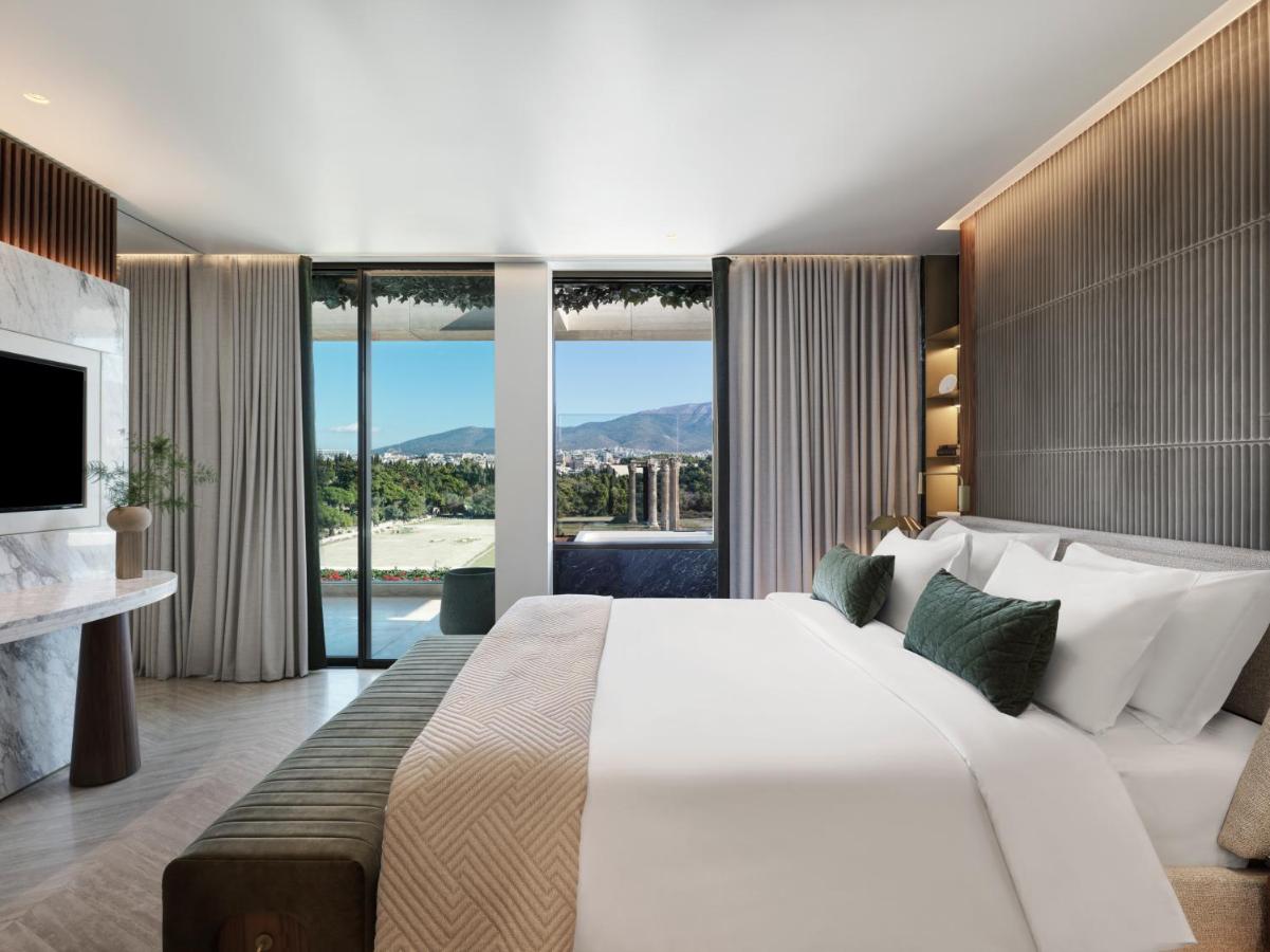 een slaapkamer met een groot wit bed en een groot raam bij Anthology of Athens, The Leading Hotels of the World in Athen