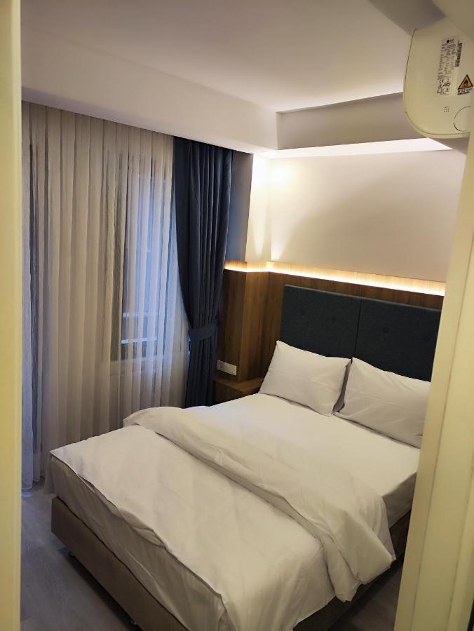 een slaapkamer met een bed met een hoofdbord en een raam bij Hotel Esve Istanbul in Istanbul