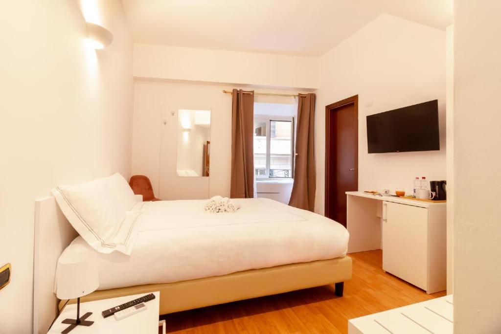 een witte slaapkamer met een bed en een keuken bij Hotel Domus Rome in Rome