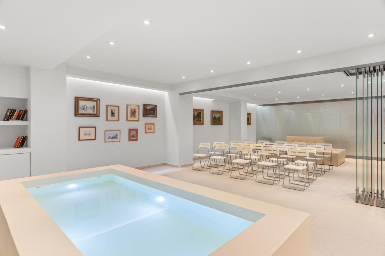 een groot zwembad in een ruimte met stoelen bij Gallery Central Piraeus Port in Piraeus