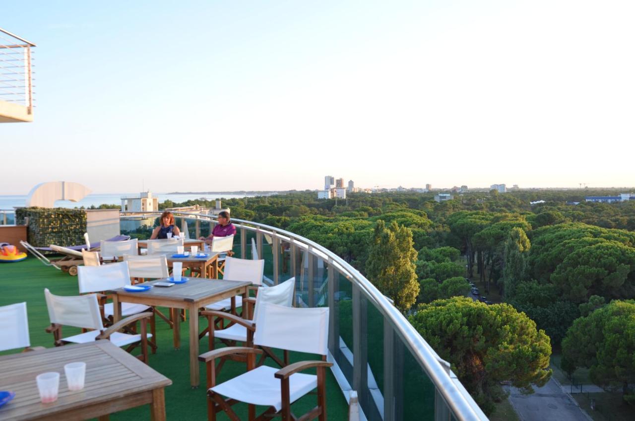 een balkon met tafels en stoelen en uitzicht bij Hotel Cristallo in Lignano Sabbiadoro