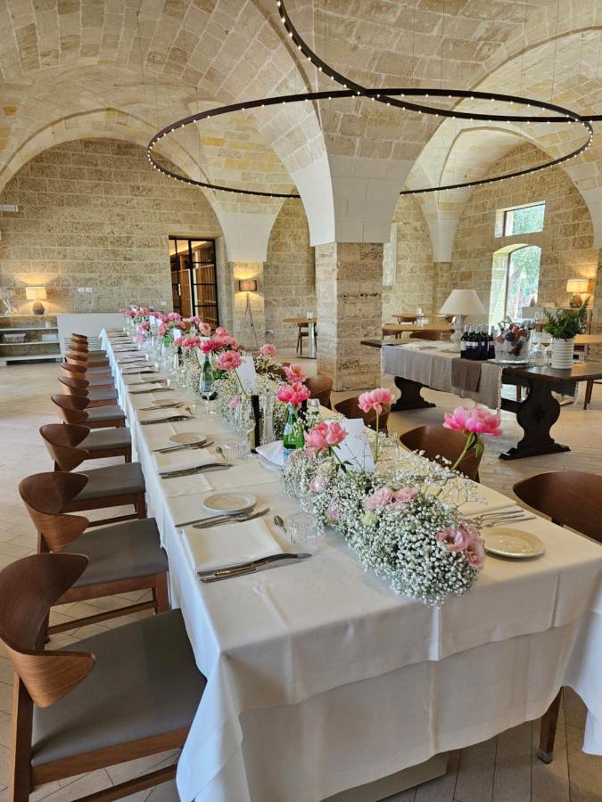 een lange witte tafel met vazen vol bloemen erop bij Secolario Masseria del Viverbene in Palmariggi