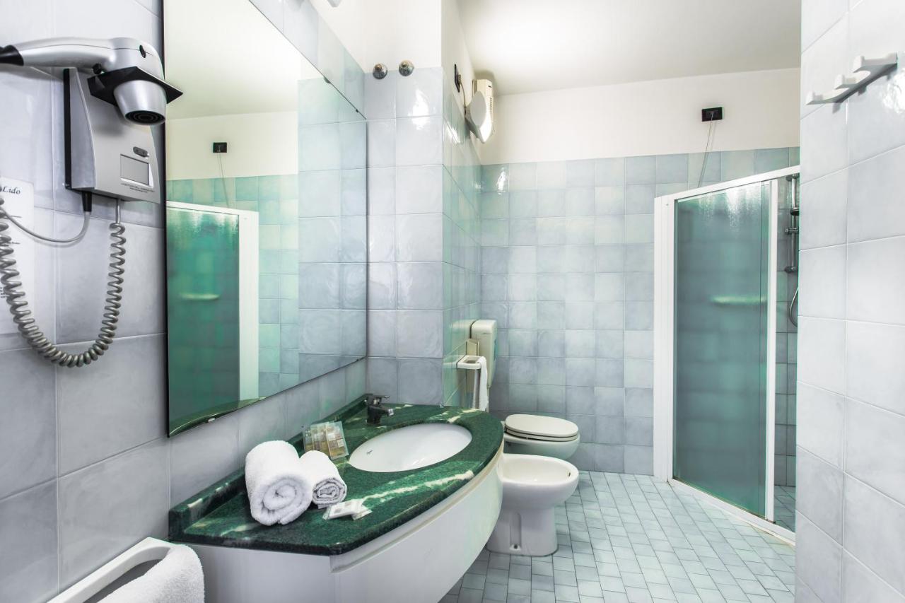 een badkamer met een wastafel, een toilet en een douche bij Lido Hotel Residence in Cesenatico