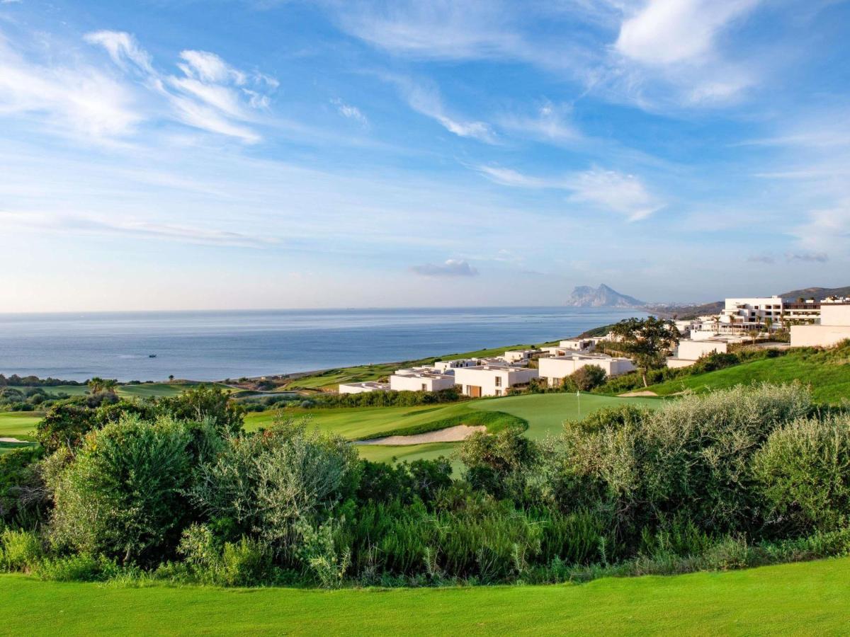 een uitzicht op een golfbaan met de oceaan op de achtergrond bij Fairmont La Hacienda Costa del Sol in Alcaidesa