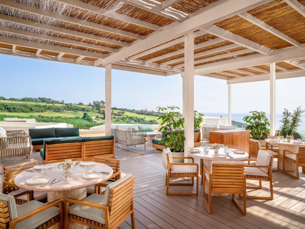 een restaurant met tafels en stoelen op een terras bij Fairmont La Hacienda Costa del Sol in Alcaidesa