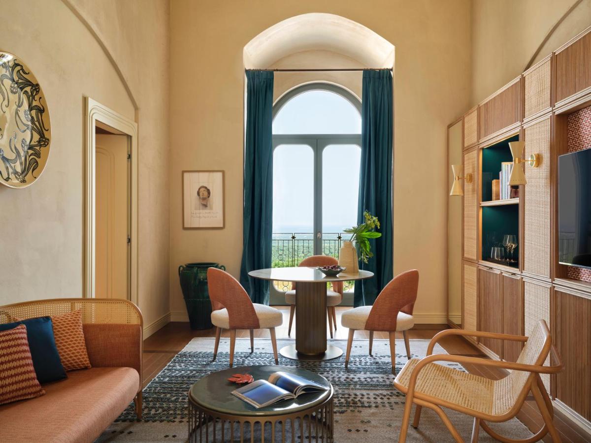 een woonkamer met een tafel en stoelen en een raam bij VISTA Ostuni in Ostuni