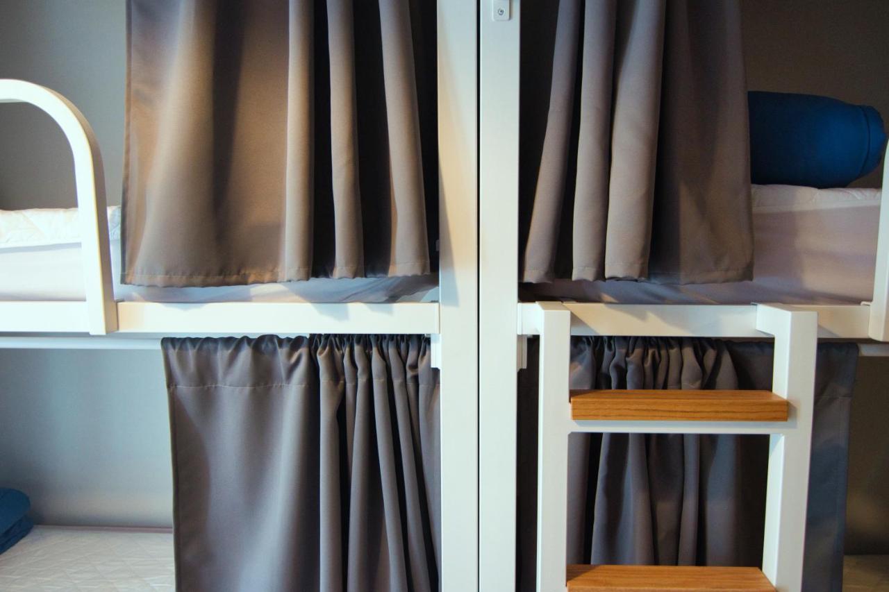 een slaapkamer met een stapelbed met een gordijn bij Factory Hostels Barcelona in Barcelona