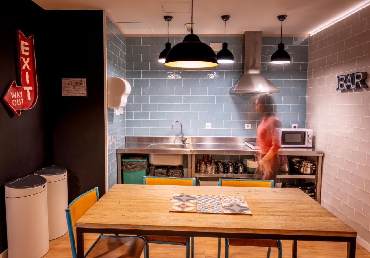 een keuken met een tafel en een persoon in de keuken bij Factory Hostels Barcelona in Barcelona