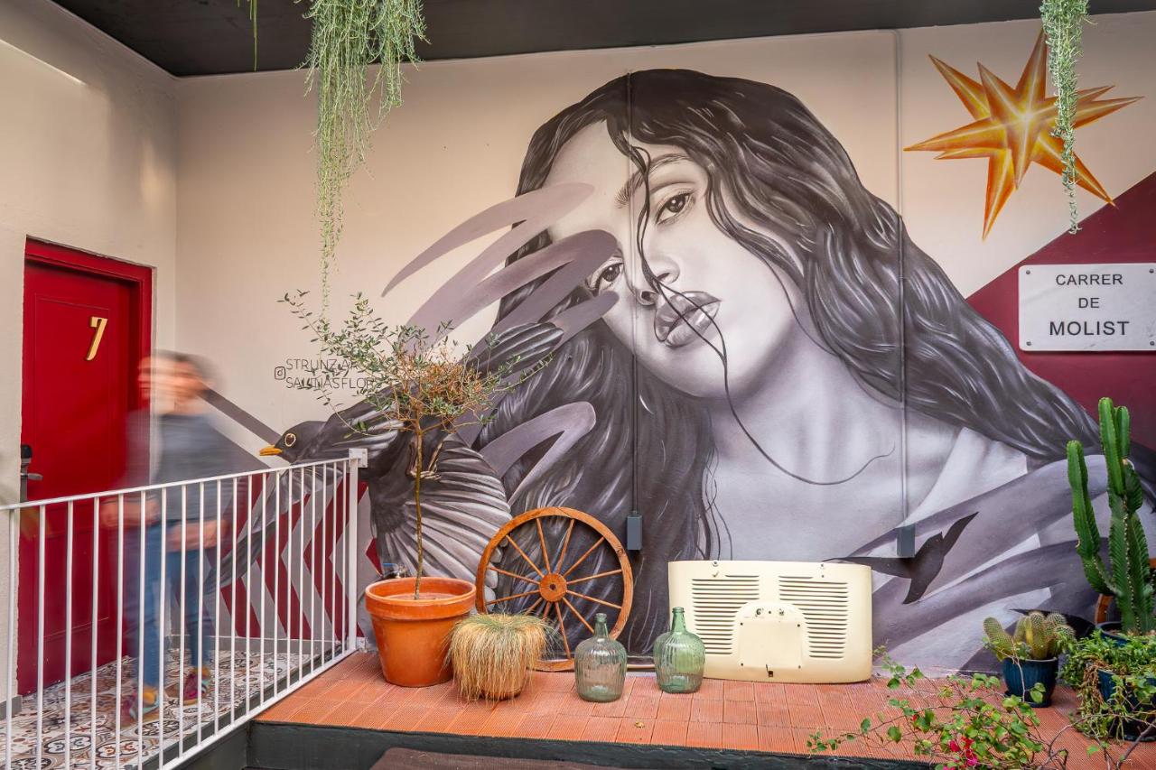 een muurschildering van een vrouw op een muur met planten bij Factory Hostels Barcelona in Barcelona