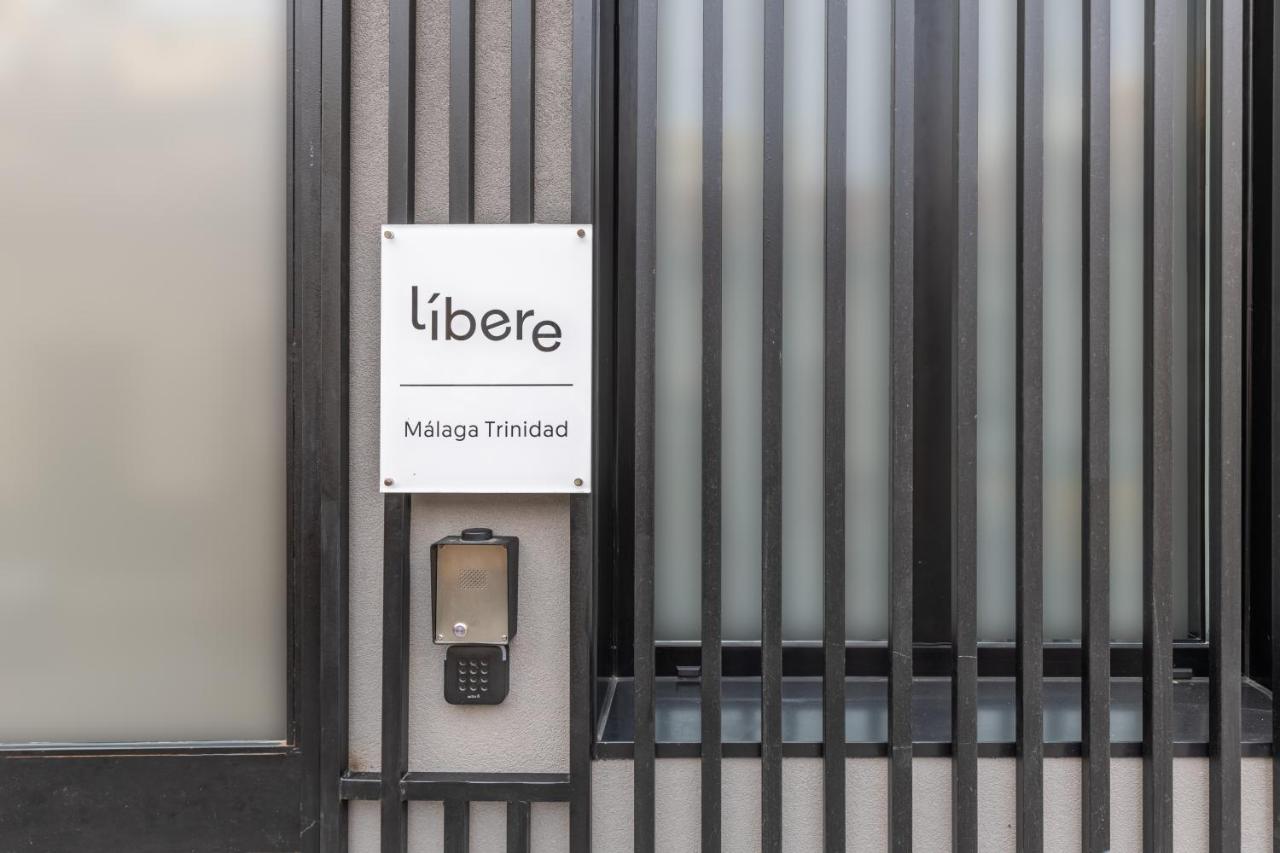 Een mobiele telefoon is aan de zijkant van een gebouw bevestigd. bij Líbere Málaga Trinidad in Málaga
