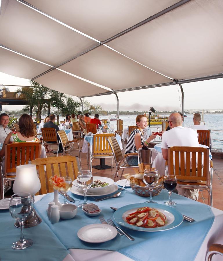 een tafel met een blauw tafelkleed waarop eten staat bij Lido Sharm Hotel Naama Bay in Sharm El Sheikh