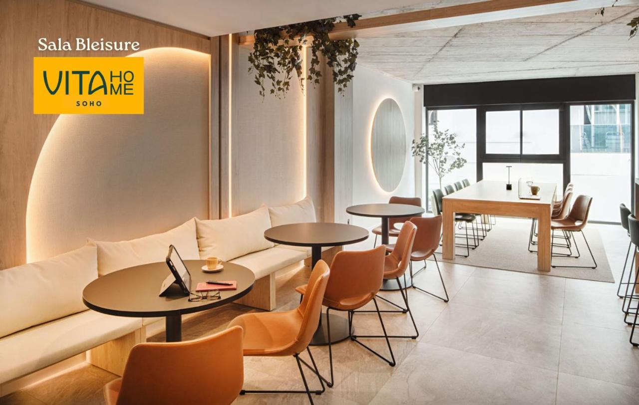 een woonkamer met een bank, tafels en stoelen bij Vita Home Lanzarote I Deluxe Apartments in Arrecife