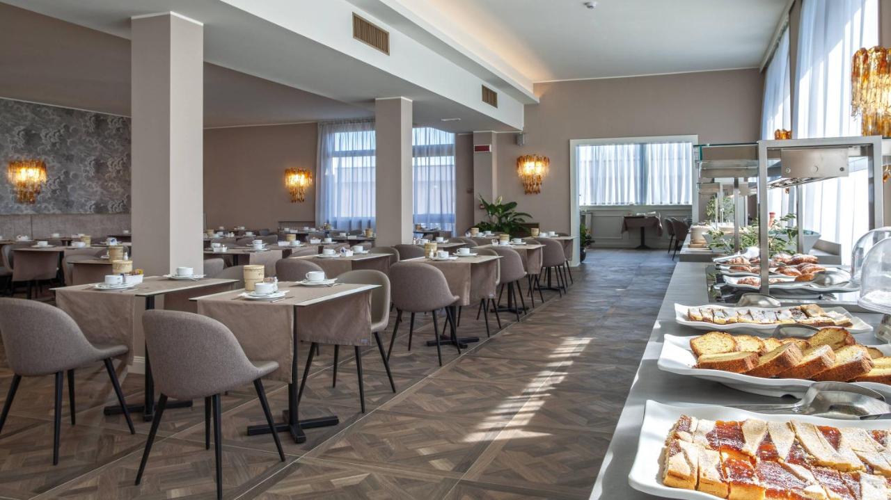 een restaurant met tafels en stoelen en gerechten die tentoongesteld staan bij Hotel Bristol Buja in Abano Terme
