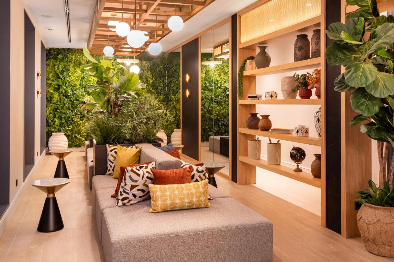 een woonkamer met een bank en planten bij Catalonia Puerta del Mar in Málaga