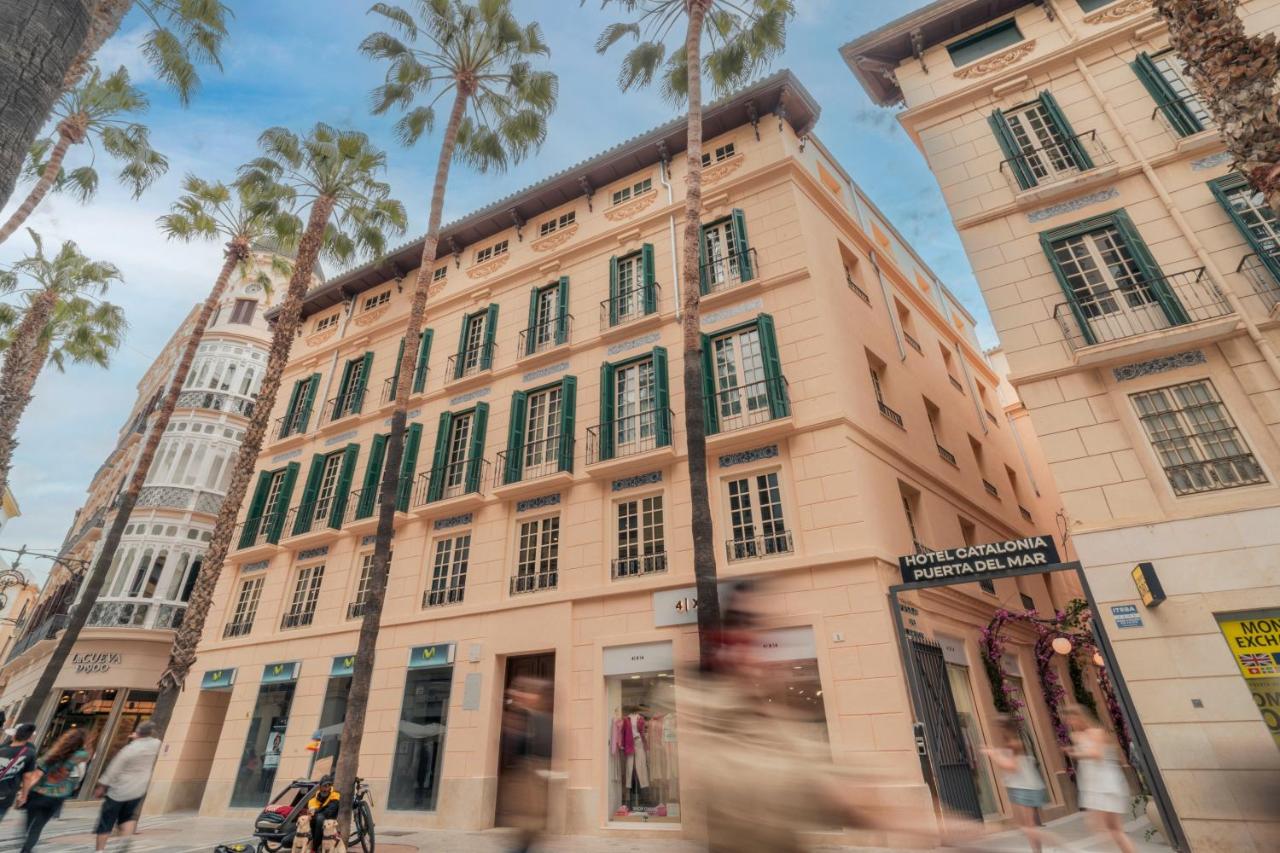 een hoog gebouw met palmbomen ervoor bij Catalonia Puerta del Mar in Málaga