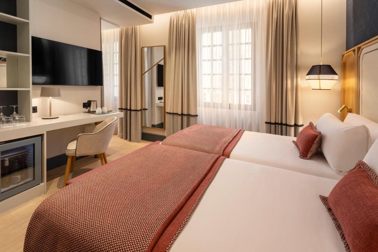 een hotelkamer met een groot bed en een keuken bij Catalonia Puerta del Mar in Málaga