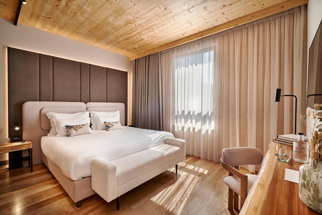 een slaapkamer met een groot wit bed en een raam bij The Log Porto Hotel by Piamonte Hotels in Porto
