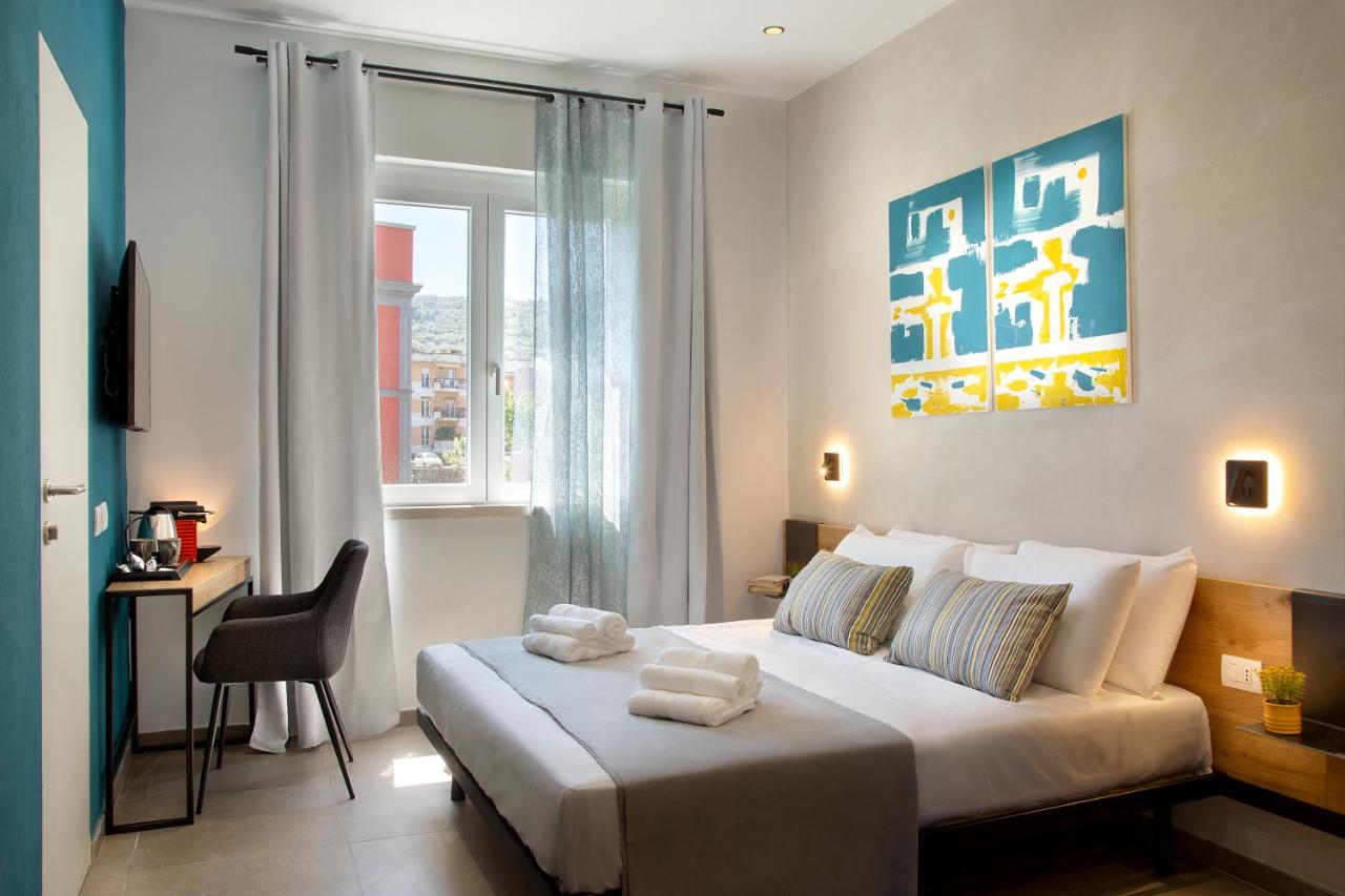 een slaapkamer met een bed, een bureau en een raam bij MARE FUORI ROOMS in Piano di Sorrento