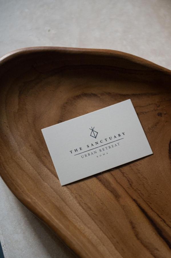 een bord dat op een houten plaat staat bij The Sanctuary Urban Retreat in Rome