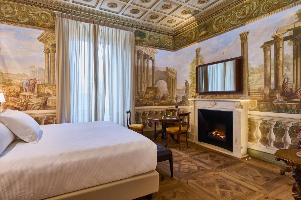 een slaapkamer met een bed en een open haard bij Duomo Luxury Florence in Florence