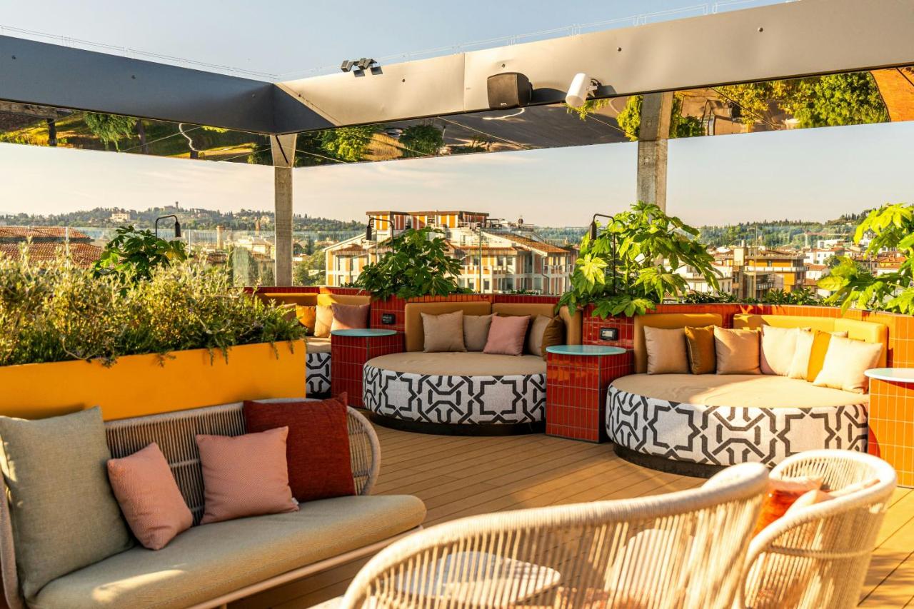 een balkon met twee bedden en stoelen op een dak bij The Social Hub Florence Belfiore in Florence