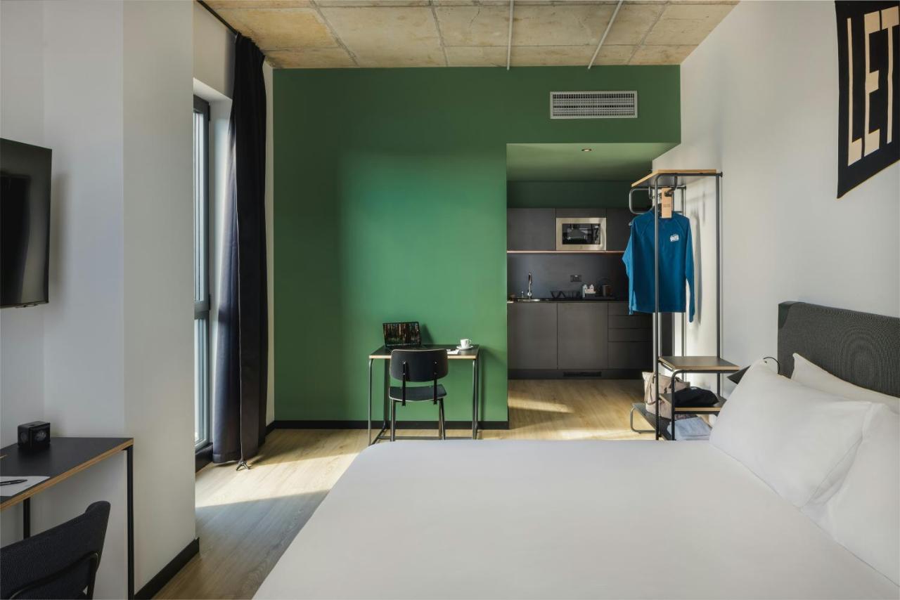 een slaapkamer met een bed en een groene muur bij The Social Hub Florence Belfiore in Florence