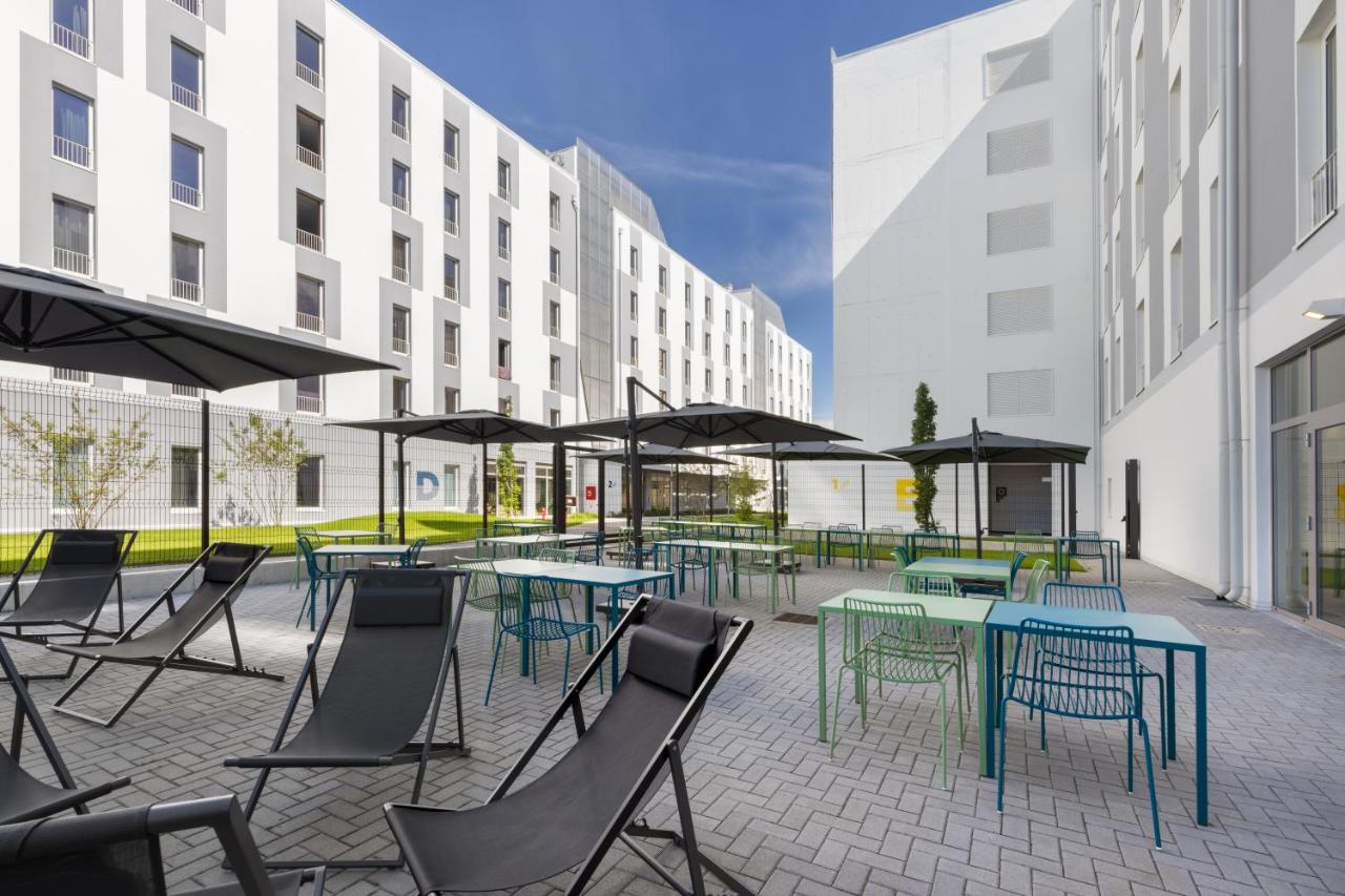 een groep tafels en stoelen met parasols bij CX Milan NoM in Milaan