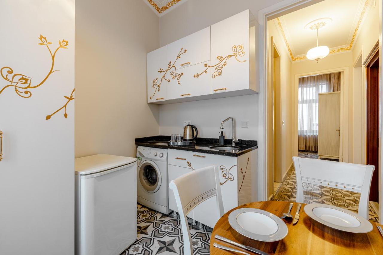 een keuken met een wasmachine en een houten tafel bij Felicity Palace Sirkeci in Istanbul