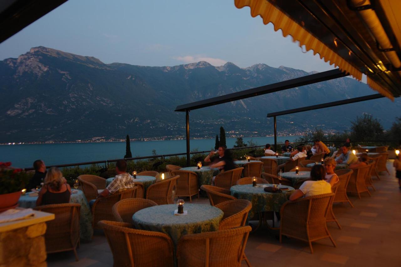 een groep mensen die aan tafels in een restaurant zitten bij Hotel Ilma Lake Garda Resort in Limone sul Garda