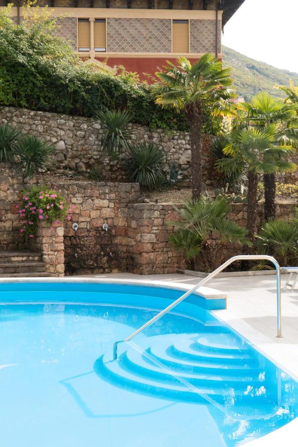 een zwembad voor een gebouw bij Hotel Drago by Double Hospitality in Brenzone sul Garda