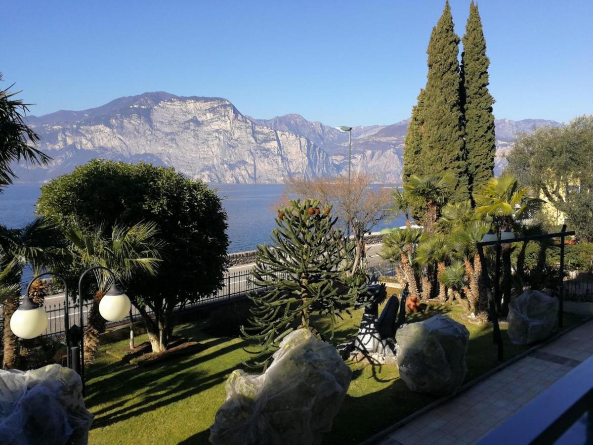 een uitzicht op de bergen vanuit een tuin met bomen bij Hotel Drago by Double Hospitality in Brenzone sul Garda
