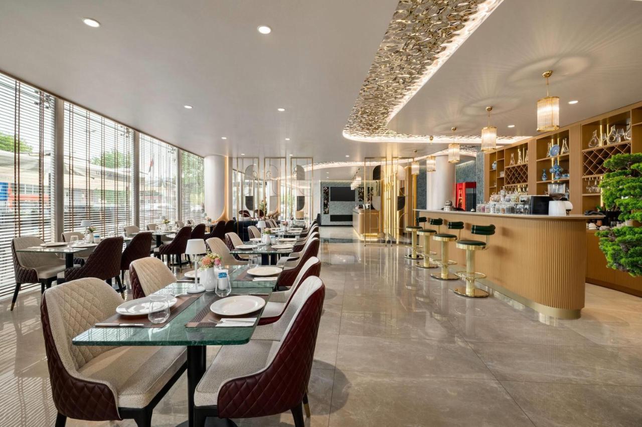 een restaurant met tafels en stoelen en een bar bij Tryp by Wyndham Istanbul Beyoglu in Istanbul