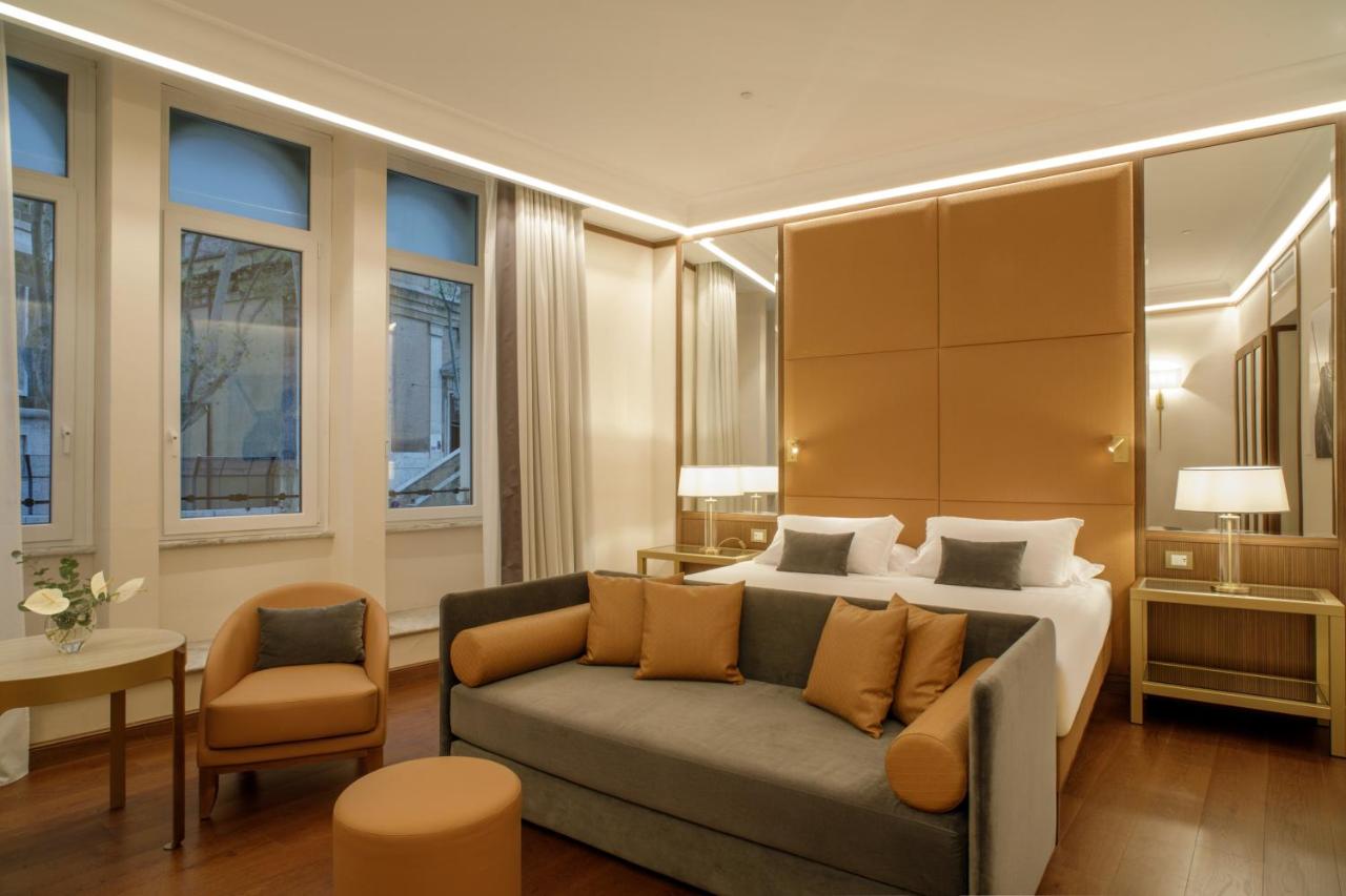 een woonkamer met een bed en een bank bij Hotel Imperiale by OMNIA hotels in Rome