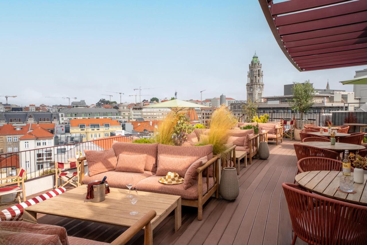 een terras met banken en tafels op een balkon bij The Social Hub Porto in Porto