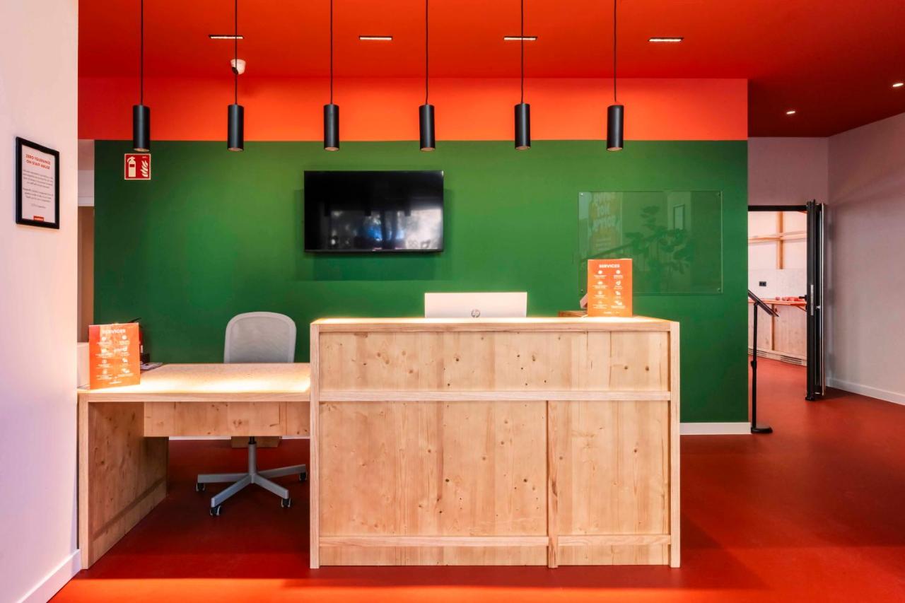 een kantoor met een bureau en een groene muur bij easyHotel Barcelona La Sagrera in Barcelona
