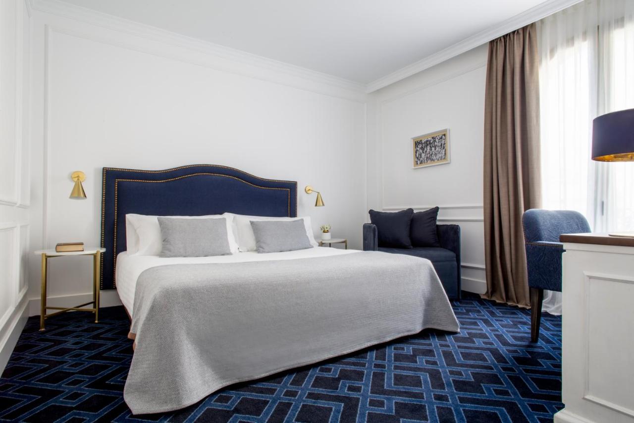 een hotelkamer met een groot bed en een stoel bij Hotel Midmost by Majestic Hotel Group in Barcelona