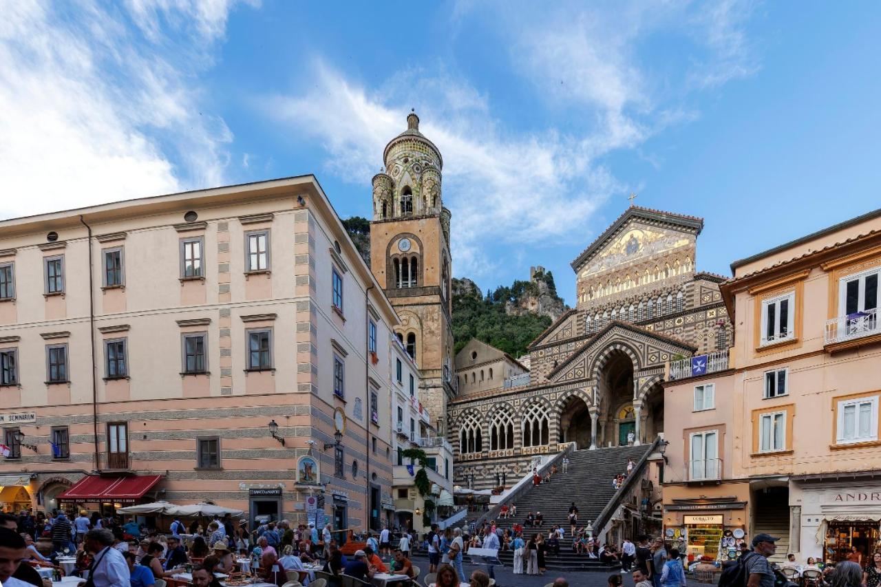 een groep mensen die rondlopen in een stad met een klokkentoren bij D'Amalfi Hospitality Sacrum Seminarium Domus Mariae 