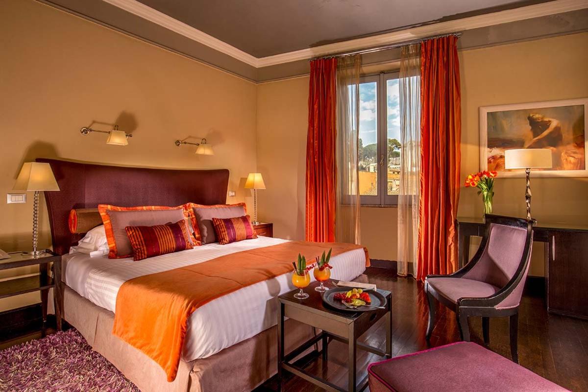 een hotelkamer met een bed, een tafel en een stoel bij The Inn at the Spanish Steps Luxury Collection - The View in Rome