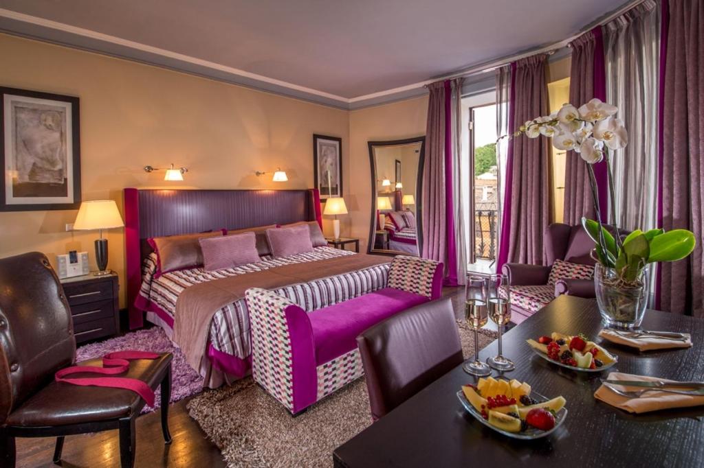 een hotelkamer met een bed, een tafel en stoelen bij The Inn at the Spanish Steps Luxury Collection - The View in Rome +