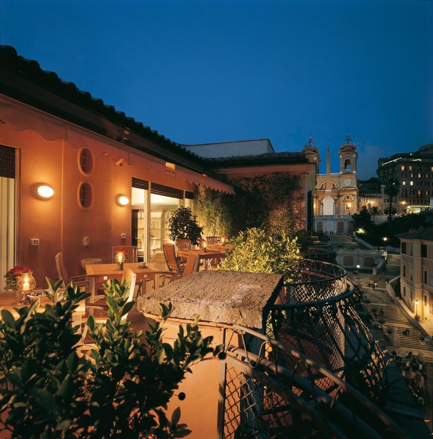 een terras buiten met tafels en stoelen 's avonds bij The Inn at the Spanish Steps Luxury Collection - The View in Rome