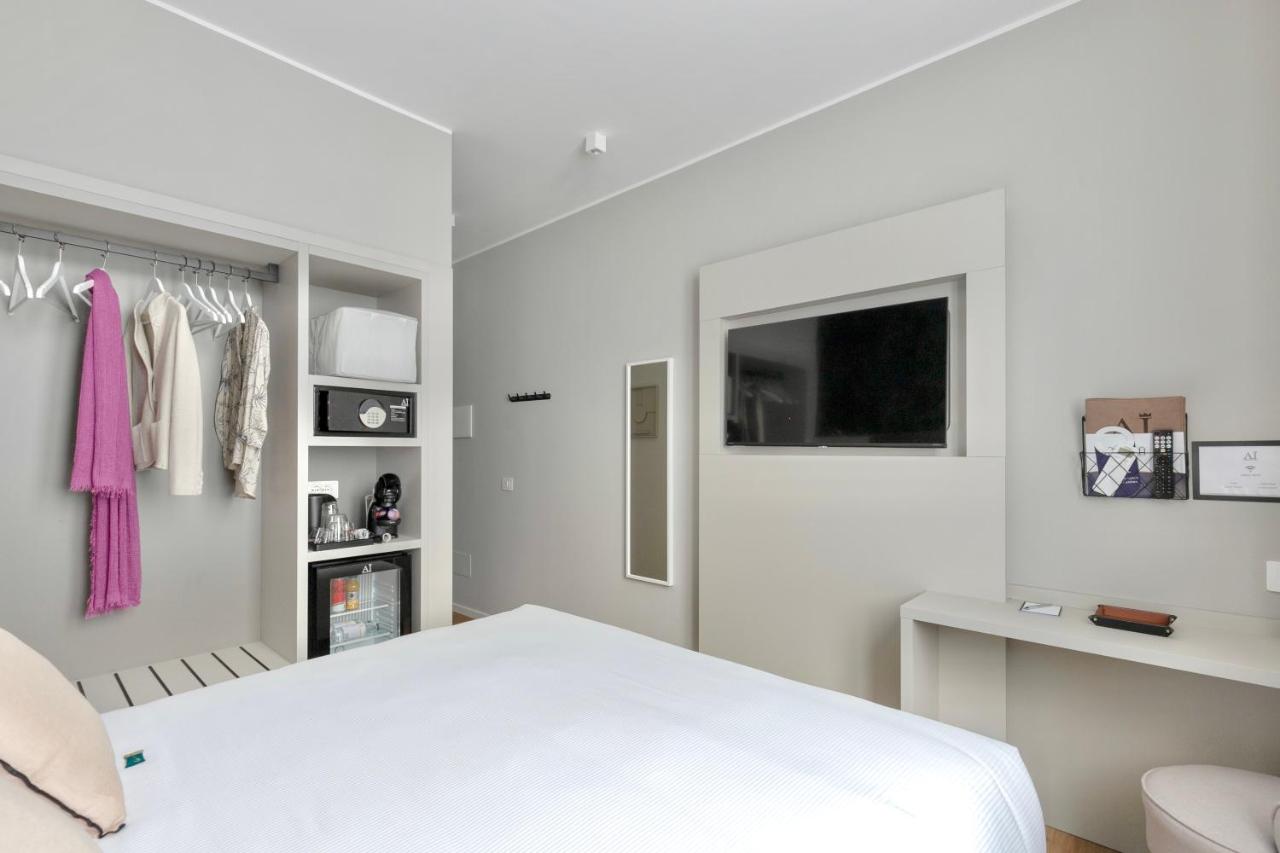 een witte slaapkamer met een bed en een tv bij AH - Duomo Signature in Milaan