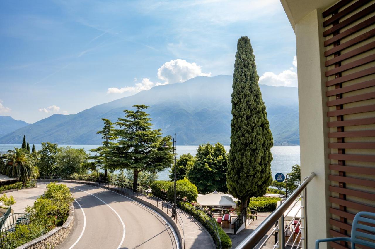 een balkon met uitzicht op een weg en bomen bij Hotel Sogno del Benaco in Limone sul Garda