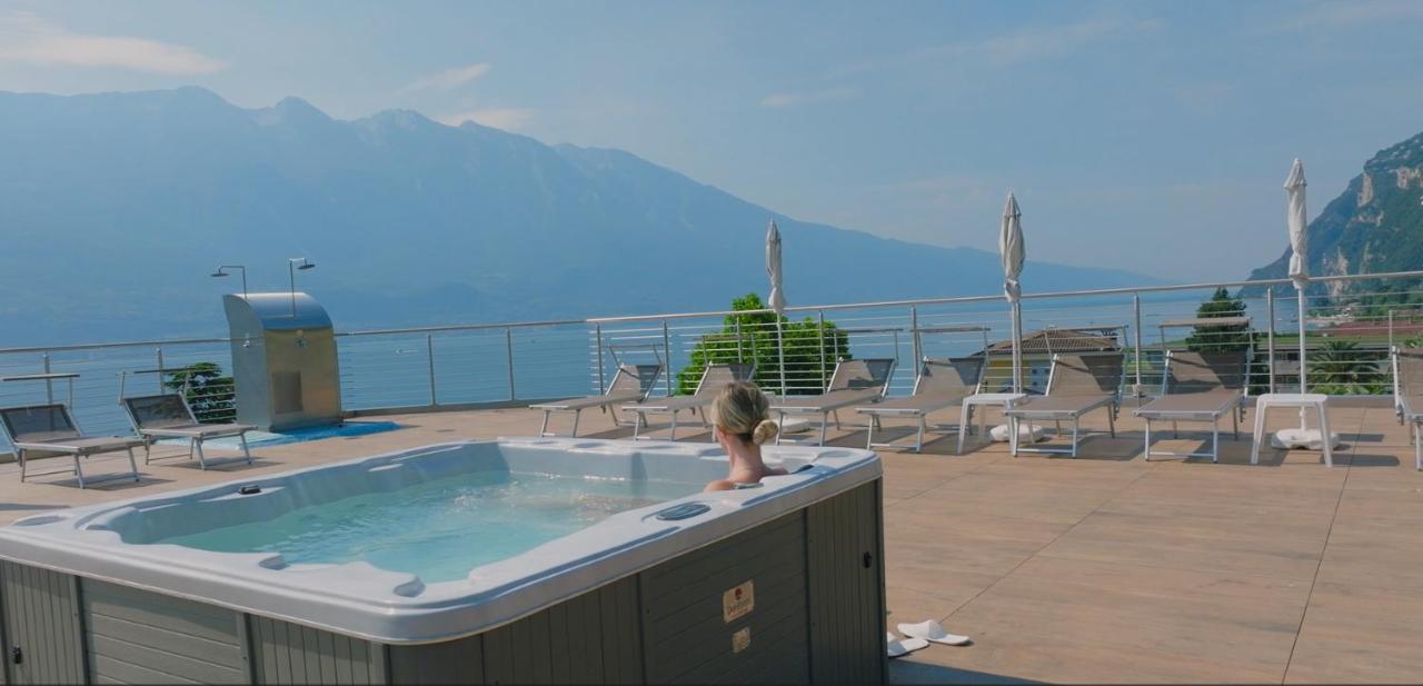 een vrouw zit in een jacuzzi op een terras bij Hotel Sogno del Benaco in Limone sul Garda